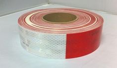 a roll of red and white tape sitting on top of a table next to a wall