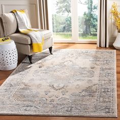 a living room area with a couch, chair and large rug on the hardwood floor