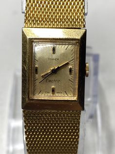 This Vintage mesh Timex electric watch is a beautiful piece of retro jewelry that would make a great gift for any woman who loves antique or vintage items. The watch features a gold tone mesh adjustable bracelet that can fit up to a 7-inch wrist comfortably. The watch is powered by a quartz movement that ensures accurate timekeeping and reliability. Although the watch has some wear and scratches, it still runs well thanks to a new battery. The overall aesthetic of the watch is retro and antique, Retro Gold Rectangular Watches, 1970s Bands, Retro Jewelry, Women Wrist Watch, Mode Vintage, Wrist Watches, Adjustable Bracelet, Vintage Charms, Quartz Movement