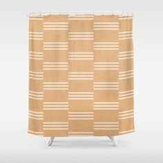 a tan and white shower curtain with horizontal stripes on it, in front of a gray background