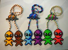 four beaded key chains with different colored cartoon characters on them, hanging from strings