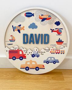 a white plate with cars and planes on it that says,'david'in blue lettering