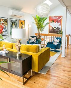 a living room with yellow couches and blue chairs