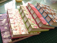 there are many books on the table with different patterns and colors, each one being folded in half