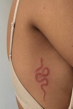 a woman's stomach with a red snake tattoo on her left side ribcage