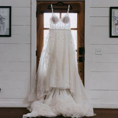 a wedding dress hanging in front of a door