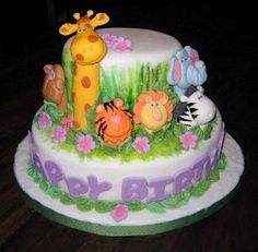 a birthday cake decorated with animals and flowers