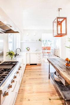 a kitchen with an island, stove and table in it's centerpieces