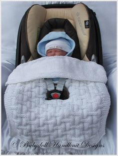 a baby in a car seat with a blanket on it's head and hat