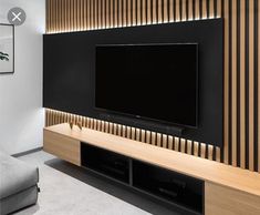 a flat screen tv mounted to the side of a wall in a modern living room