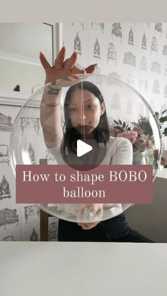 a woman holding up a balloon with the words how to shape bobo balloon in front of her face