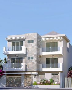 a white two story building with balconies on the first floor and second story