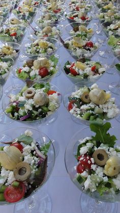 a table topped with lots of clear bowls filled with different types of food and veggies