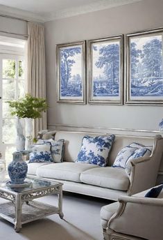 a living room with blue and white decor on the walls, couches and coffee table