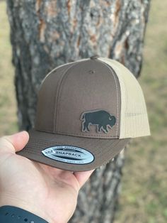 "Design: Bison Hat Looking for that special gift? Each hat is made to order just for you and/or loved one! Please don't hesitate to contact us for custom requests or wholesale information. Sign Up For Our Newsletter At: www.BlackHillsWildwoods.com  FEATURES  * Yupoong 6606 Adult Six Panel Adjustable Snapback Hat With Leatherette Patch * Hat Color Options: Brown/Khaki, Navy/Silver, Marron/Grey, Charcoal/Black, Moss/Khaki & Grey/Black (Please see the photo slide for color samples.) * 65/35 Polyest Brown Baseball Cap For Outdoor, Brown Adjustable Hat With Curved Bill, Brown Fitted Hat With Flat Bill, Brown Adjustable Curved Bill Hat, Brown Outdoor Hat With Curved Bill, Brown Baseball Cap As A Gift, Adjustable Brown Baseball Cap, Brown Flat Bill Baseball Cap For Gift, Brown Curved Bill Hat For Gift