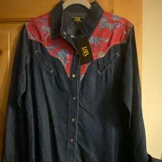 Lightweight Denim With Horse Motif Yoke Dark Wash Cotton Tops For Rodeo, Denim Blue Long Sleeve Top For Rodeo, Denim Blue Tops For Rodeo, Dark Wash Tops For Fall Rodeo, Western Style Blue Tops For Spring, Blue Shirt For Spring Rodeo, Blue Shirt For Rodeo In Spring, Western Denim Blue Denim Tops, Denim Button-up Tops For Rodeo