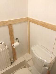 a white toilet sitting in a bathroom next to a radiator