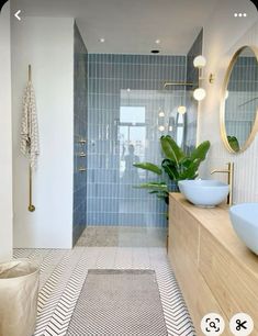 a bathroom with two sinks and a large mirror on the wall next to a walk in shower