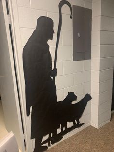 a silhouette of a man with an umbrella and two dogs in front of a door