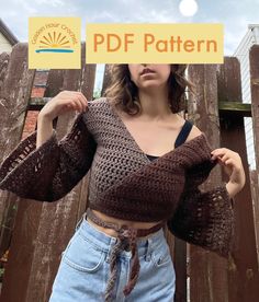 a woman wearing a brown crochet crop top and blue jeans is holding up a sign that says pdf pattern