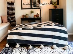 a black and white striped blanket sitting on top of a bed