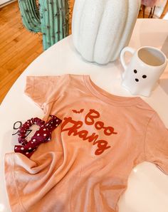 Get your little boo thang ready for spooky season with this peach-colored shirt or onesie. Perfect for toddlers and babies, this shirt features the playful phrase "boo thang." Get ready for Halloween in style! Material: 100% Cotton Screen Printed in Mesa, Arizona by a mama! Girl Falling, Swim Accessories, Diy Baby Stuff, Onesies, Baby Onesies, Screen Printing, Colorful Shirts