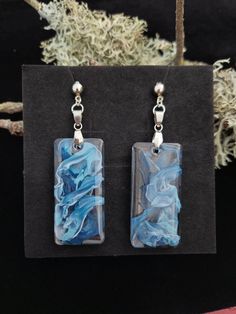 two square shaped earrings with blue and white swirls