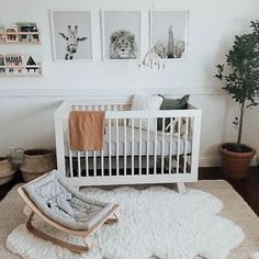 a baby's room with a white crib and pictures on the wall