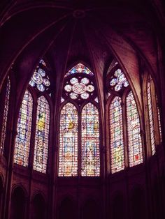 three stained glass windows in an old church