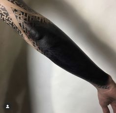 a man's arm with tattoos on it and his hand holding the other arm