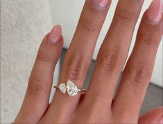 a woman's hand with a diamond ring on it