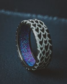 View all font options and engraving info HERE. Product Details Ring Style: "Echo" is a handcrafted, custom embossed men's wedding ring featuring a dragon scale engraving with a purple opal lining. It can be customized to feature just about any embossed design you can dream up. Width: The width of the ring pictured is 8mm wide but can be ordered in a custom width accompanied by a design change fee. Please state your desired width in the Custom Requests section during checkout, and we will reach o Purple Opal, Dragon Scale, Men's Wedding Ring, Embossed Design, A Dragon, Ring Style, Wedding Ring, Opal, Band