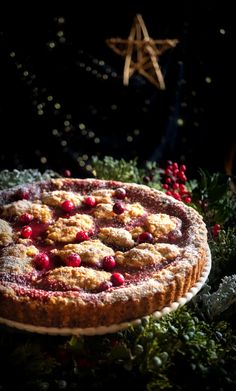 a pie with cranberries and powdered sugar on it