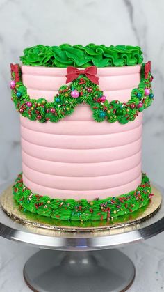 a pink and green decorated cake sitting on top of a table