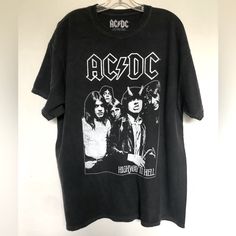 Ac/Dc Band Tee Featuring A Front Ac/Dc Graphic Above An Image Of The Band, World Tour 1979 Concert , 100% Cotton , Crew Neck, Short Sleeve T Shirt New 1x Chest 24.5” Length 30” Ac/Dc Highway To Hell Graphic T Shirt Black Deadstock Graphic Tee, Black Graphic Tee From Deadstock, Vintage Black Shirt For Fans, Edgy Cotton Tops For Fan Merchandise, Black Short Sleeve Tops With Band Logo, Black Short Sleeve Top With Band Logo, Black Band Logo Crew Neck Top, Black Band Logo Shirt For Summer, Black Crew Neck Tops With Band Logo