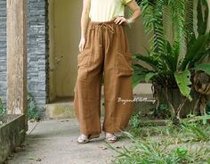 "A simply soft, comfy, wide leg boho gaucho pants with 2 patched pockets and elastic waist. Every day fit from day to night with this comfy pants or even make it as your favorite traveling pants. Perfect pieces for the summer and spring. Easy pair it with simple top. Material: double gauze cotton, elastic band Weight: 314g Measurement: free size pants (approximately) Elastic waist: 28\"-42\"  (with adjustable drawstring) Hip: 54\" can fit up to hip max 48\" Length: 38\" Inseam length: 27\" - col Wide Leg Harem Pants With Pockets For Beach, Casual Brown Baggy Harem Pants, Wide Leg Harem Pants With Pockets For Vacation, Bohemian Solid Color Harem Pants For Vacation, Vacation Baggy Wide Leg Pants, Bohemian Solid Wide Leg Pants With Pockets, Wide Leg Pants For Vacation, Spring Brown Wide Leg Pants With Side Pockets, Comfortable Summer Harem Pants