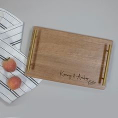 two peaches sitting on top of a cutting board next to a knife and napkin