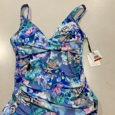 Nwt $88 Blue Chateau Floral Print. 4-Way Stretch. Twist Detail At Neckline. Tummy Control. Removable Soft Cups. Adjustable Straps. Lined. Hits At The Waist. Blue Swim Dress With Built-in Bra For Summer, Blue Sleeveless Tankini With Built-in Bra, Calvin Klein Beachwear For Poolside, Blue Fitted Tankini For Beachwear, Fitted Blue Tankini For Beachwear, Fitted Blue Tankini Beachwear, Calvin Klein Stretch Swimwear For Poolside, Fitted Ruched Swimwear For Vacation, Spring Lined Tankini For Pool