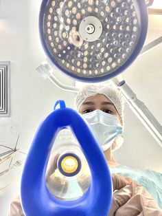 a person in scrubs and surgical gear holding up a light