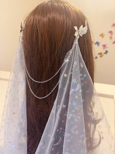 the back of a woman's head wearing a veil with stars on it