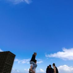 three people are flying a kite in the sky on a sunny day at the beach