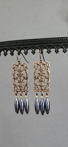 Adorn yourself with these  beautiful golden antiqued bronze plated earrings with intricate details and vintage Austrian Hematite Crystals.  These earrings are 2.0 " inches long and lightweight.    All materials sourced in The United States, Italy, The United Kingdom, Austria, Spain and Portugal.  All my jewelry is made and designed with love for you to express yourself and your life with happiness , beauty and spirit. Victorian Gold Earrings With Antique Finish, Victorian Gold Chandelier Earrings, Victorian Gold Metal Chandelier Earrings, Bronze Metal Pierced Chandelier Earrings, Ornate Bronze Filigree Earrings, Ornate Earrings With Antique Finish, Ornate Bronze Metal Earrings, Bronze Antique Finish Dangle Earrings, Antique Gold Copper Earrings With Antique Finish