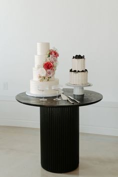 two tiered cakes sitting on top of a black and white table next to each other