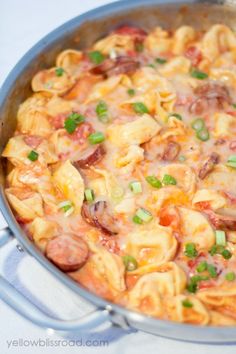 a pan filled with pasta and vegetables on top of a stove