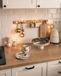 a kitchen counter topped with a pie and cupcake next to a stove top oven