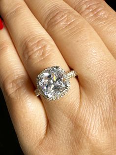 a woman's hand with a ring on it and a diamond in the middle