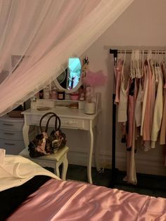 a bedroom with a pink bed and white dresser next to a mirror on the wall