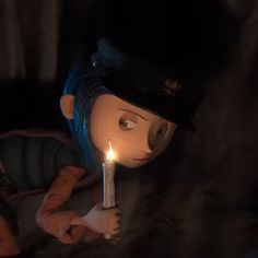 a doll holding a lit candle in the dark