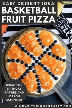 a pizza with blueberries and oranges on it sitting on top of a table