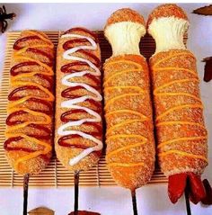 four hotdogs with different toppings on sticks